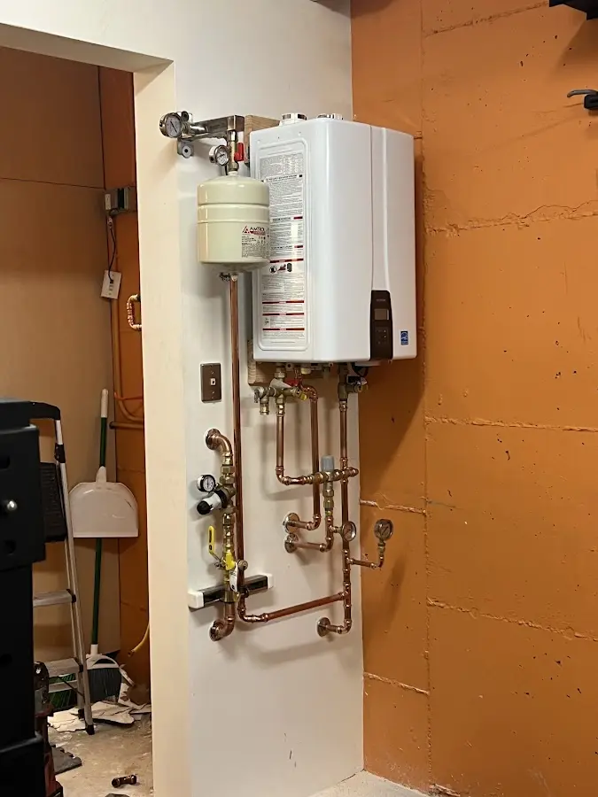Plumbing technician inspecting water heater connections in Garden City